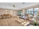 Spacious living room with wood floors, neutral walls, and plenty of natural light from large windows at 1353 Camelot Ct, Palm Harbor, FL 34684