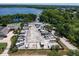 Aerial view of RV parking area surrounded by lush greenery, and a neighboring home on a sunny day at 1353 Camelot Ct, Palm Harbor, FL 34684