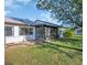The back of the home with a sunroom and landscaping in the backyard at 1353 Camelot Ct, Palm Harbor, FL 34684