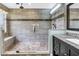 Elegant bathroom featuring a tiled shower, glass enclosure, bench, and vanity at 13785 Oak Forest S Blvd, Seminole, FL 33776