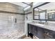 Bathroom featuring a walk-in shower with tile surround and a black granite vanity at 13785 Oak Forest S Blvd, Seminole, FL 33776