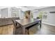 Open floor plan featuring dining area with farmhouse table and living room with fireplace and large windows at 13785 Oak Forest S Blvd, Seminole, FL 33776