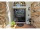Elegant double front doors with decorative wreaths, brick porch, and stylish outdoor lighting fixture at 13785 Oak Forest S Blvd, Seminole, FL 33776