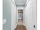 Hallway leading to the bathroom, featuring two closets and laminate wood flooring at 13785 Oak Forest S Blvd, Seminole, FL 33776