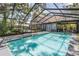 An in-ground pool surrounded by a screened enclosure, offering a private outdoor retreat at 13785 Oak Forest S Blvd, Seminole, FL 33776