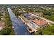 An aerial view of a stunning waterfront home featuring a pool, outdoor kitchen, patio, and private dock at 13878 Allamanda Cir, Port Charlotte, FL 33981