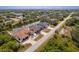 An aerial view showcases a waterfront home with a pool, patio, dock, and 2-car garage nestled in lush greenery at 13878 Allamanda Cir, Port Charlotte, FL 33981
