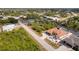 An aerial view captures a waterfront house featuring a pool, patio, dock and lush, green landscaping at 13878 Allamanda Cir, Port Charlotte, FL 33981