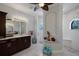 Elegant bathroom features a dark wood vanity with marble countertop, arched shower entry and stained glass window at 13878 Allamanda Cir, Port Charlotte, FL 33981