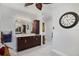 Bathroom with dark wood vanity with marble countertops, view of the toilet room, and large decorative clock at 13878 Allamanda Cir, Port Charlotte, FL 33981