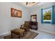 Bedroom features comfortable seating, a side table with a mirror, and a beautiful window with natural light at 13878 Allamanda Cir, Port Charlotte, FL 33981