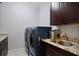 Laundry room features a dark wood vanity, sink, and front loading washer and dryer at 13878 Allamanda Cir, Port Charlotte, FL 33981