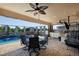 An outdoor kitchen is adjacent to the covered patio which includes a fan, grill and an outdoor dining area at 13878 Allamanda Cir, Port Charlotte, FL 33981