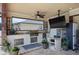 Covered outdoor summer kitchen with granite counters, stainless grill, and outdoor television at 13878 Allamanda Cir, Port Charlotte, FL 33981