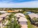 Aerial view of a home with manicured lawn and landscaping, situated by a scenic lake at 16106 Cedar Key Dr, Wimauma, FL 33598