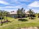 Aerial view of backyard with mature landscaping, lawn and a screened lanai at 16106 Cedar Key Dr, Wimauma, FL 33598