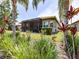 Well maintained backyard has mature tropical landscaping, manicured lawn and a screened lanai at 16106 Cedar Key Dr, Wimauma, FL 33598