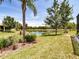 Lush backyard with well-maintained lawn and view of a tranquil lake at 16106 Cedar Key Dr, Wimauma, FL 33598