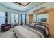 Spacious bedroom with a king bed, dresser, a purple chair and natural light, creating a cozy atmosphere at 16106 Cedar Key Dr, Wimauma, FL 33598