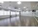 Open dance studio featuring hardwood floors, mirrors, ballet bars, and natural light for a creative workout space at 16106 Cedar Key Dr, Wimauma, FL 33598