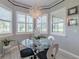 Breakfast nook has bright windows, pendant lighting and a modern glass table and chairs at 16106 Cedar Key Dr, Wimauma, FL 33598