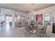 Elegant dining room with modern chandelier, glass table, and artwork creating a sophisticated ambiance at 16106 Cedar Key Dr, Wimauma, FL 33598