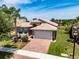 Charming home with a brick driveway, tile roof, and meticulously landscaped front yard at 16106 Cedar Key Dr, Wimauma, FL 33598