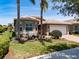Charming single-Gathering home with mature palm trees, flowering plants, and attached garage at 16106 Cedar Key Dr, Wimauma, FL 33598