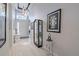 Light-filled hallway with tiled floors, art, and view of the front door at 16106 Cedar Key Dr, Wimauma, FL 33598