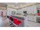 Bright kitchen features white cabinets, stainless steel appliances and a counter with bar stool seating at 16106 Cedar Key Dr, Wimauma, FL 33598