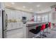 Bright kitchen features white cabinets, stainless steel appliances and a counter with bar stool seating at 16106 Cedar Key Dr, Wimauma, FL 33598