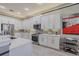 Bright kitchen features white cabinetry, stainless appliances, tile backsplash and light countertops at 16106 Cedar Key Dr, Wimauma, FL 33598