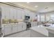 Bright kitchen features white cabinetry, stainless appliances, tile backsplash and light countertops at 16106 Cedar Key Dr, Wimauma, FL 33598