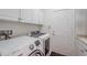 Efficient laundry room with modern appliances, white cabinets, and ample counter space at 16106 Cedar Key Dr, Wimauma, FL 33598