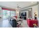 Spacious living room features large windows, modern fireplace, and tray ceiling at 16106 Cedar Key Dr, Wimauma, FL 33598