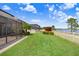 Well-manicured backyard with lush lawn and a white picket fence overlooking a serene lake view at 1830 Nature View Dr, Lutz, FL 33558