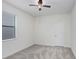 Bright bedroom featuring a ceiling fan, neutral carpet and a window for natural light at 1830 Nature View Dr, Lutz, FL 33558