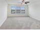 Bedroom featuring three windows that allow lots of natural light and gray carpet at 1830 Nature View Dr, Lutz, FL 33558