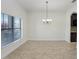 Dining room features tile floors, a modern chandelier, and abundant natural light at 1830 Nature View Dr, Lutz, FL 33558