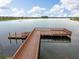 Picturesque aerial view of the wooden dock with a seating area, providing a perfect spot for fishing or relaxing at 1830 Nature View Dr, Lutz, FL 33558
