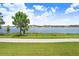 Scenic lake view with a tree and sidewalk in the foreground, capturing the community's natural beauty at 1830 Nature View Dr, Lutz, FL 33558