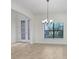 Bright living room featuring a stylish chandelier and a decorative glass front door that brings in natural light at 1830 Nature View Dr, Lutz, FL 33558