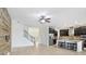 Open concept living room featuring tile floors, ceiling fan, stairs, and kitchen with island seating at 1830 Nature View Dr, Lutz, FL 33558