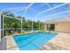 Screened pool with attached spa has views of the water and green landscaping, with outdoor seating at 18819 Rue Loire St, Lutz, FL 33558