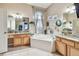 Bright bathroom featuring a soaking tub, dual vanities with granite countertops, and decorative art at 1939 Heartland Cir, Valrico, FL 33594