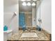 Bright bathroom with granite counters, blue decorative accents and shower with patterned curtain at 1939 Heartland Cir, Valrico, FL 33594