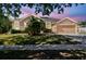 Charming single-story home with a well-manicured lawn, two-car garage, and beautiful landscaping at 1939 Heartland Cir, Valrico, FL 33594
