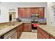 Kitchen with dark wood cabinets, granite countertops, stainless steel appliances, and a tiled backsplash at 1939 Heartland Cir, Valrico, FL 33594