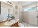 Bathroom featuring a shower and single sink with a wood cabinet and bright window at 2019 Rutherford Dr, Dover, FL 33527