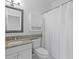 Bathroom with granite countertop vanity, framed mirror, and shower with curtain at 202 S Lincoln Ave, Tampa, FL 33609
